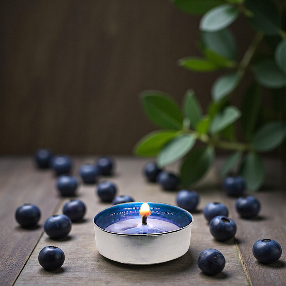Blue tealight candle surrounded by blueberries on a wooden surface with a plant in the background. 4 hour burn. Soy Wax