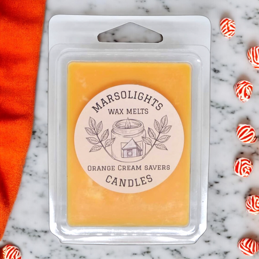 Creme Saver Wax Melts on a Marble counter with creme saver candies surounding it. Colour pattern is similar to a peppermint. Notes of Citrus, Butter and Vanilla