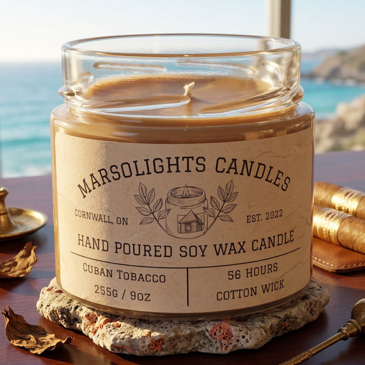 Cuban Tobacco Soy Candle displayed with warm, tobacco-inspired décor. The candle features sweet mango, spicy cardamom and tobacco leaf notes with sage, wormwood, jasmine, sandalwood, cedarwood and creamy tonka bean. 9 ounce or 255 grams, 56-hour burn time, cotton wick, soy candle, made in Canada, paraben free.