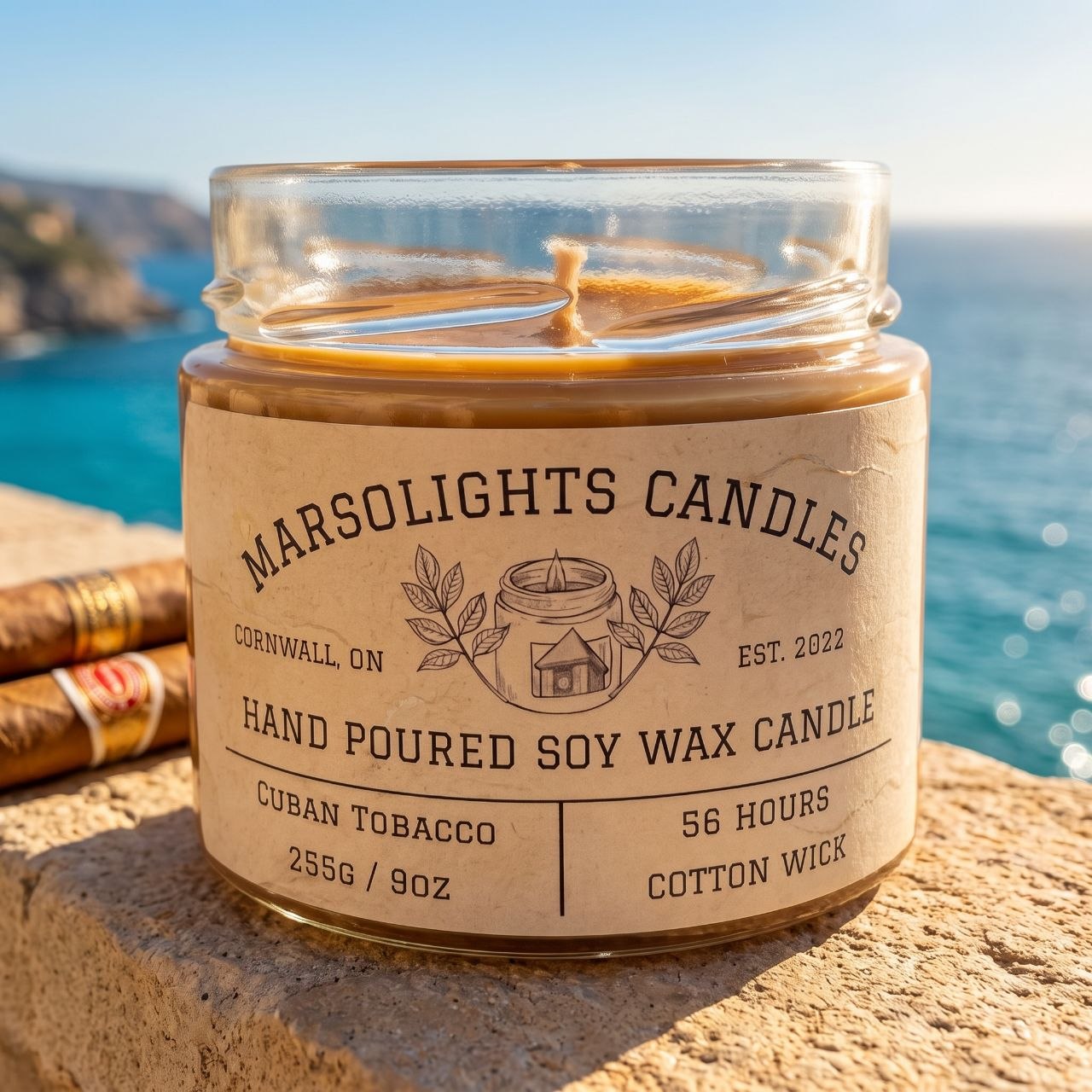 Cuban Tobacco Soy Candle displayed with warm, tobacco-inspired décor. The candle features sweet mango, spicy cardamom and tobacco leaf notes with sage, wormwood, jasmine, sandalwood, cedarwood and creamy tonka bean. 9 ounce or 255 grams, 56-hour burn time, cotton wick, soy candle, made in Canada, paraben free.