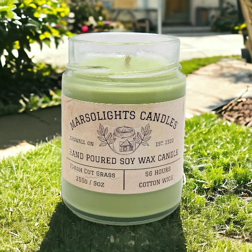 Green candle in a glass jar with a label on grass. 255g Soy Wax Fresh cut grass scented soy candle. 56 hour burn time. Cotton wick. 255g or 9oz 
